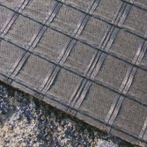 Vista detallada de la capa de rejilla de refuerzo de asfalto HaTelit de HUESKER.
