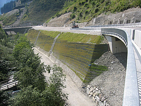 Geomalla ecológica Fortrac T para la estabilización de taludes junto a una carretera, fabricada con PET 100% reciclado