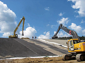 Con la ayuda de dos cargadoras sobre ruedas y la instalación de geosintéticos, se construye un cuerpo de vertedero