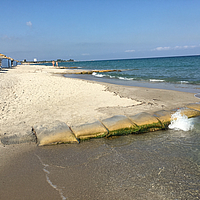 Bolsas SoilTain en la orilla de una playa de arena turística