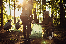 Voluntarios recogen botellas de plástico en el bosque para fabricar geomallas ecológicas Fortrac T con PET 100% reciclado