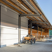 Almacén con puerta enrollable Lubratec para protegerlo de la intemperie