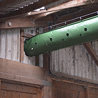 Close-up of the bottom view of the Tube Air ventilation hose in a cow barn.