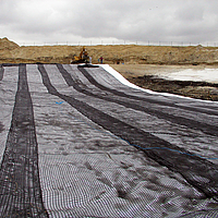 Despliegue de la geomalla Basetrac Grid con una viga de elevación para el refuerzo de la capa de base en una obra