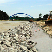 Geotextil no tejido y piedras en el borde del río para proteger las orillas