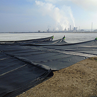 Los trabajadores separan el tejido de refuerzo Basetrac® Woven para su instalación