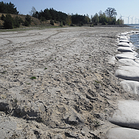 Bolsas SoilTain en acción como protección costera en una orilla arenosa