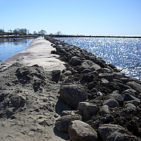 Presa de geosintéticos, revestida de piedras y arena